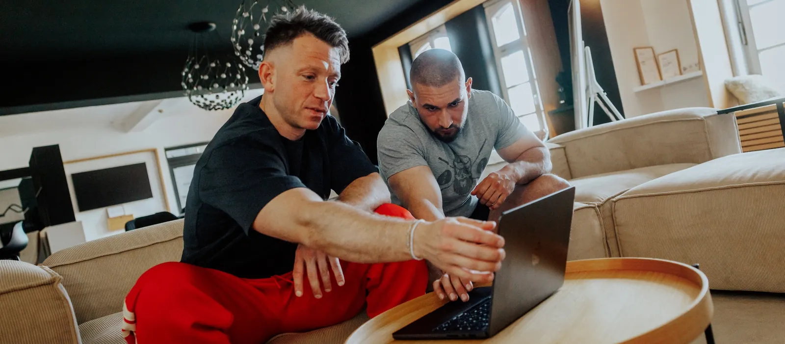 Trainer und Klient besprechen den Trainingsplan am Laptop